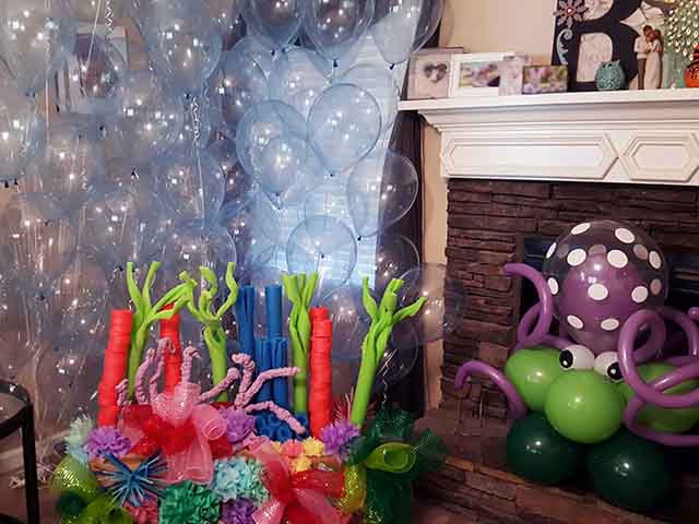 Helium balloon backdrop with a handmade under the sea theme craft and a balloon octopus on the right side