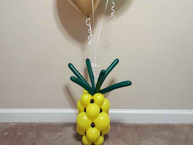 Balloon bouquet with a pineapple balloon design as the base