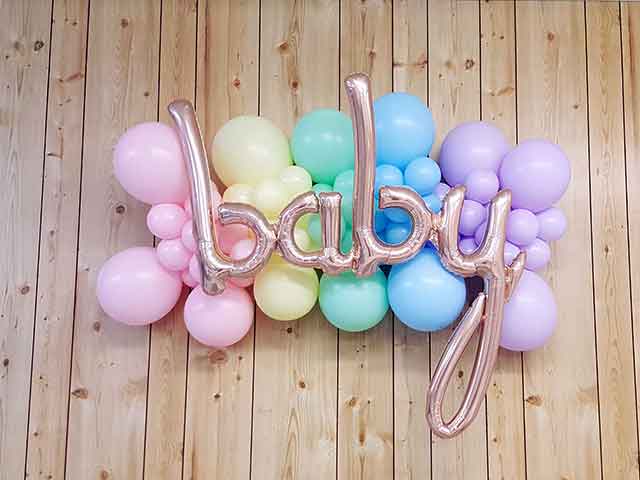 Small balloon backdrop with the word baby in front